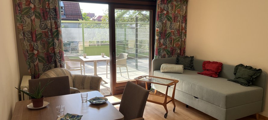 Mit Sofa, Tisch und Stühlen eingerichtetes Apartment