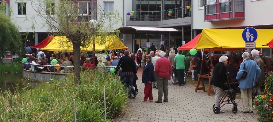 Fest vor dem Haus im Park mit Luftballons und Sitzbänken