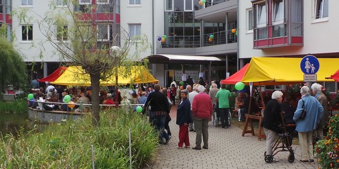 Fest vor dem Haus im Park mit Luftballons und Sitzbänken