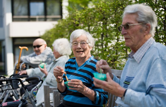 Senioren essen im Garten Eis.