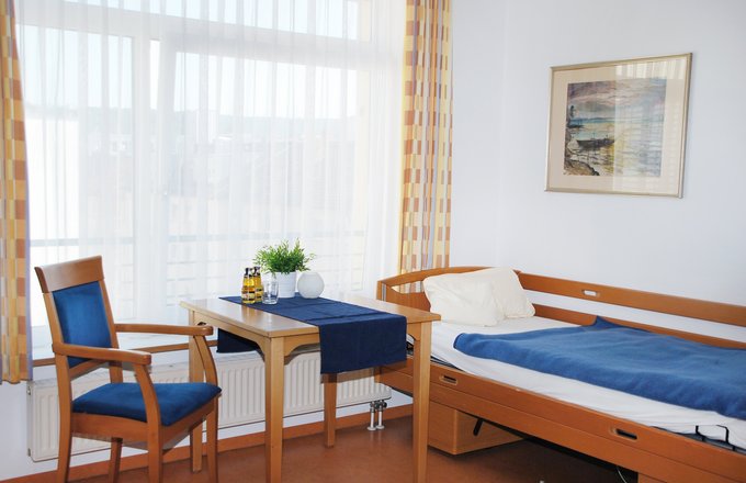 Bewohnerzimmer mit Bett, Tisch und Stuhl