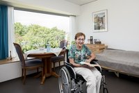 Seniorin im Rollstuhl in ihrem Zimmer