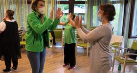 Inhouse-Schulung im Altenburgheim Frauen stehen sich paarweise gegenüber und klatschen sich gegenseitig mit den Händen ab