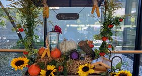 Planwagen mit Holzdach und Herbstdeko aus Sonnenblumen, Stroh und Kürbissen