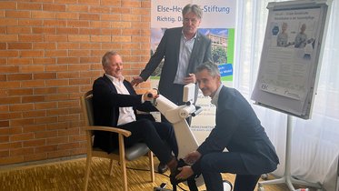 Der Gesundheitsminister und Projektpartner testen ein Trainingsgerät.