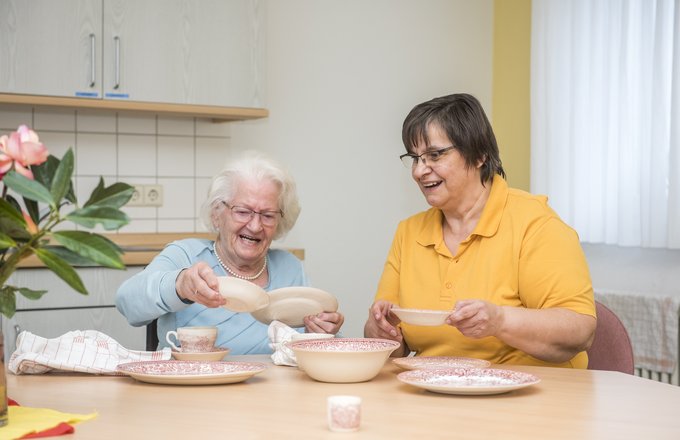 Seniorin und Mitarbeiten mit Geschirr